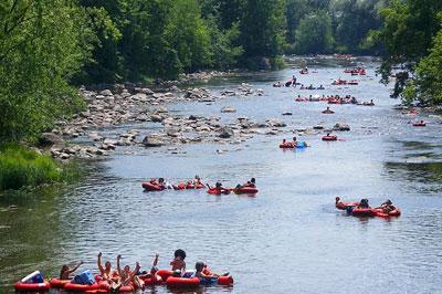 Dozens of visitors tubing down a river in Smoky Mountains National Park